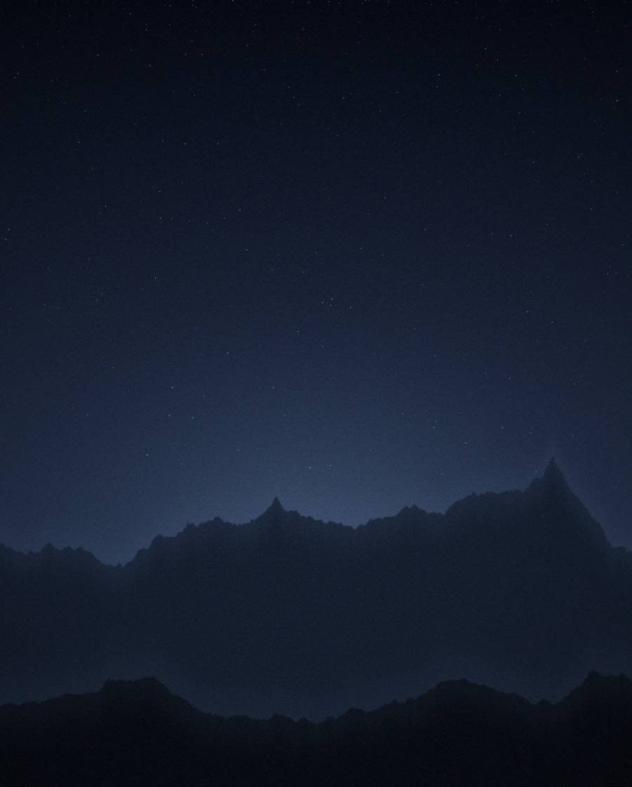 Star field over a dark ridgeline
