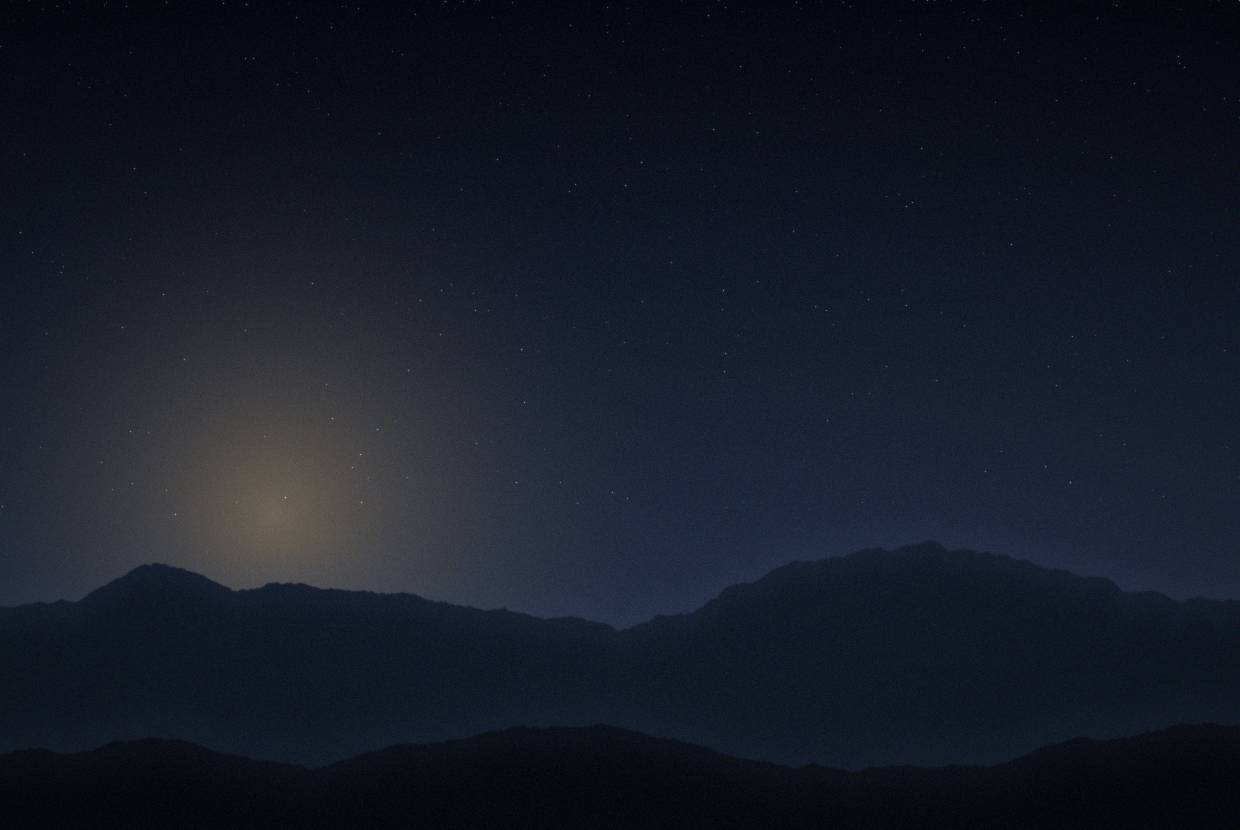 Moonrise behind distant ridges